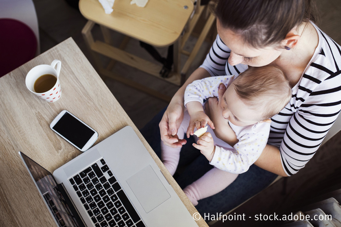 Frau mit Kleinkind am Laptop